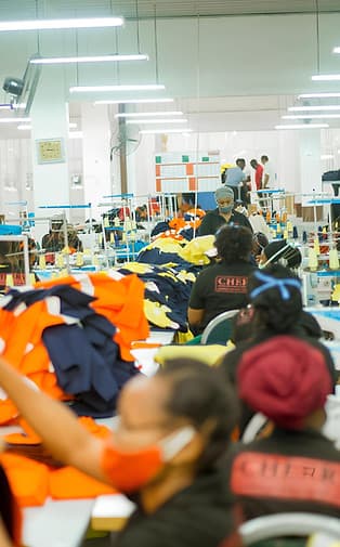 Workers sewing high-visibility workwear on the Cherry Garments factory floor