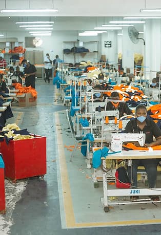 Rows of industrial sewing stations inside the workwear production facility